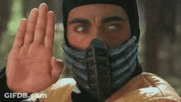 A Man With A Mask On His Face Is Making A Stop Sign With His Hand . GIF