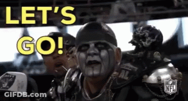 A Man With A Mask On His Face Is Sitting In A Stadium And Says Let 'S Go ! GIF