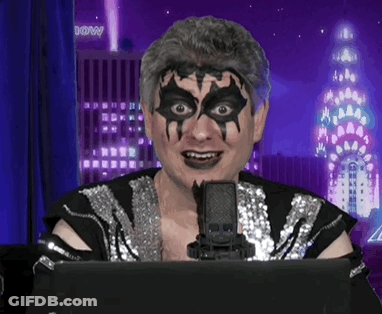 A Man With A Mask On His Face Is Sitting In Front Of A Microphone With A Building In The Background That Has The Word Do GIF