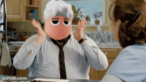 A Man With A Mask On His Face Is Talking To A Woman In A Kitchen GIF