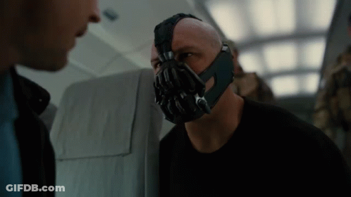 A Man With A Mask On His Face Talking To Another Man GIF