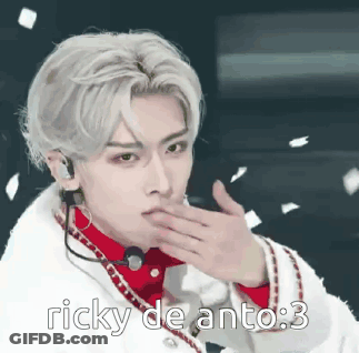 A Man With A Microphone On His Ear Is Blowing A Kiss While Wearing A White Coat . GIF