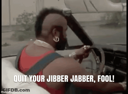 A Man With A Mohawk Is Driving A Car With The Words `` Quit Your Jibber Jabber Fool '' Written On The Screen . GIF