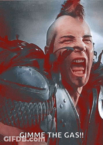 A Man With A Mohawk Is Screaming With The Words Gimme The Gas GIF
