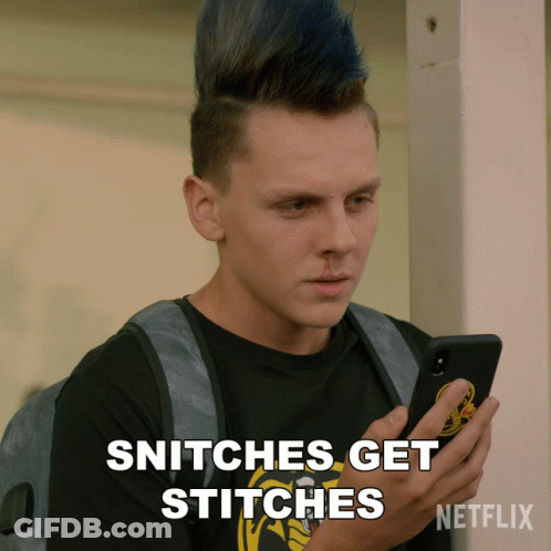 A Man With A Mohawk Looks At His Phone And Says Snitches Get Stitches Netflix GIF