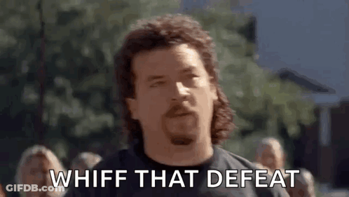 A Man With A Mullet And A Beard Is Standing In Front Of A Crowd And Saying Whiff That Defeat . GIF