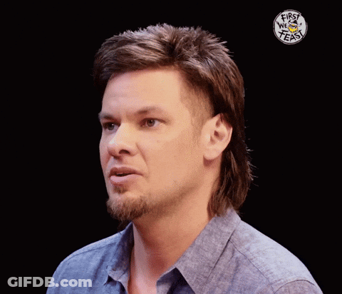 A Man With A Mullet Has The Words First We Feast On His Shirt GIF