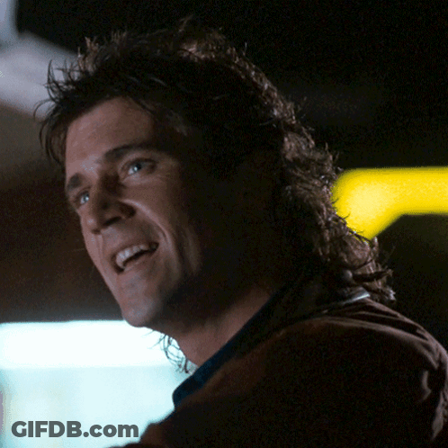 A Man With A Mullet Is Smiling And Looking Up GIF