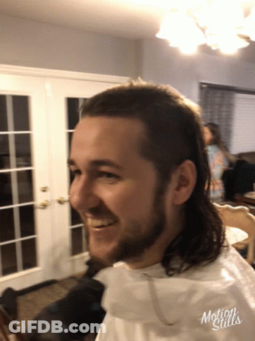 A Man With A Mullet Is Smiling In A Motion Stills Photo GIF