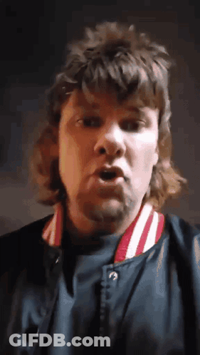 A Man With A Mullet Is Wearing A Blue Jacket With Red And White Stripes GIF