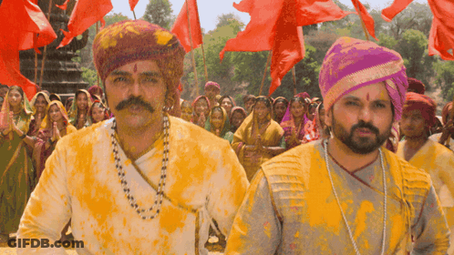 A Man With A Mustache And A Necklace Is Covered In Yellow Paint GIF