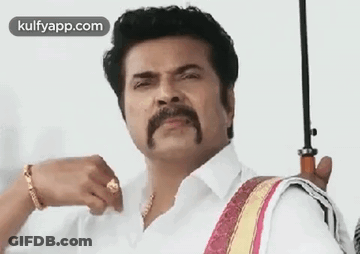 A Man With A Mustache And A Ring Is Holding An Umbrella . GIF