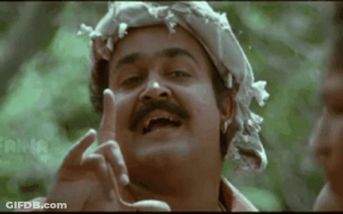 A Man With A Mustache And A Scarf Around His Head Is Making A Funny Face . GIF