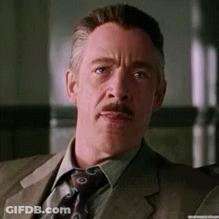 A Man With A Mustache And A Suit And Tie Is Making A Funny Face . GIF