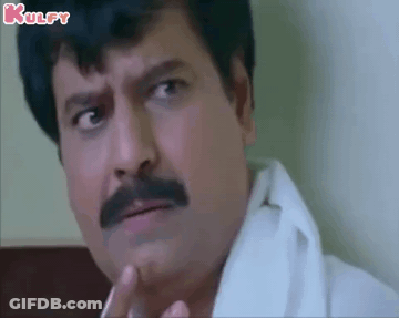 A Man With A Mustache And A White Shirt Is Making A Funny Face While Smoking A Cigarette . GIF