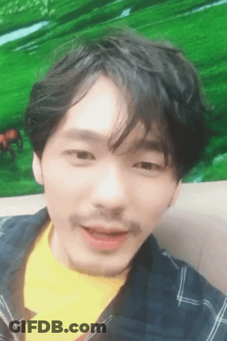A Man With A Mustache And A Yellow Shirt Is Smiling GIF