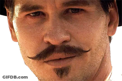 A Man With A Mustache And Beard Looks At The Camera GIF