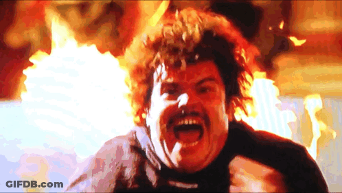 A Man With A Mustache And Curly Hair Is Screaming In Front Of A Fire GIF