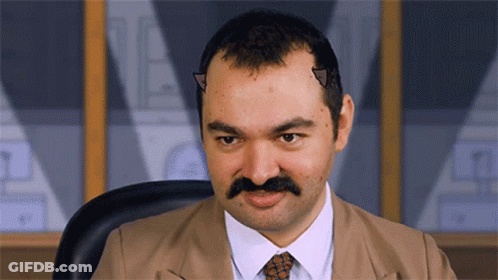 A Man With A Mustache And Horns On His Head Looks At The Camera GIF