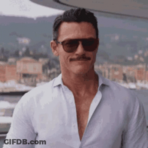 A Man With A Mustache And Sunglasses Is Wearing A White Shirt . GIF