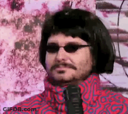A Man With A Mustache And Sunglasses Is Wearing A Wig And Tie . GIF