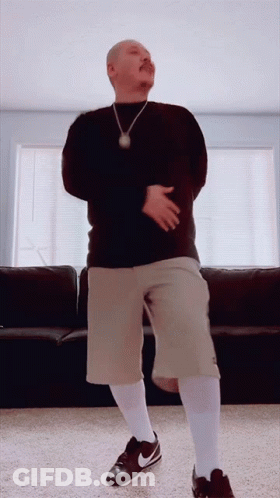 A Man With A Mustache Is Dancing In A Living Room GIF