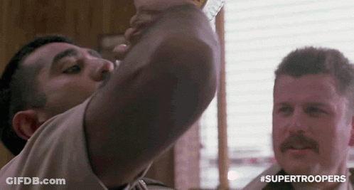 A Man With A Mustache Is Drinking From A Glass . GIF