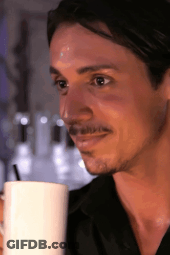 A Man With A Mustache Is Drinking From A White Mug With A Straw GIF