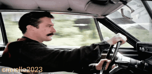A Man With A Mustache Is Driving A Car In A Photo Taken By Cravello20203 GIF