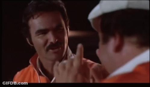 A Man With A Mustache Is Giving The Middle Finger To Another Man GIF