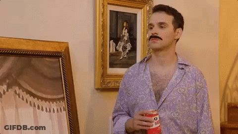 A Man With A Mustache Is Holding A Can Of Pringles GIF