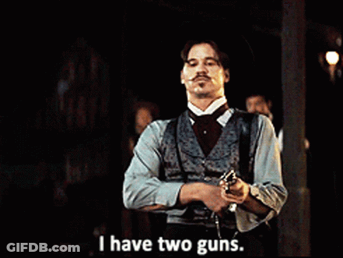 A Man With A Mustache Is Holding A Gun And Says I Have Two Guns GIF