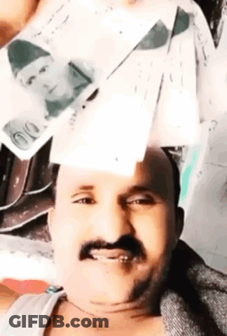 A Man With A Mustache Is Holding A Stack Of Money In Front Of His Face . GIF