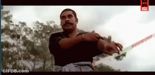 A Man With A Mustache Is Holding A Sword In His Right Hand . GIF