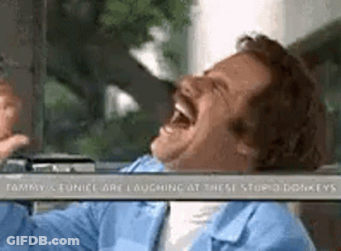 A Man With A Mustache Is Laughing In A Car . GIF