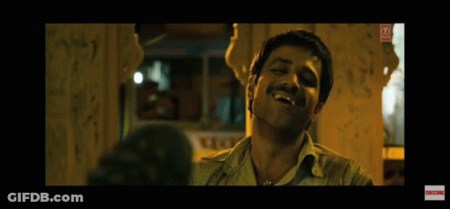 A Man With A Mustache Is Laughing In A Dark Room With Graffiti On The Wall . GIF