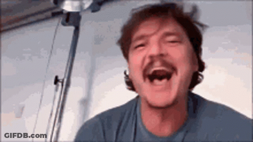 A Man With A Mustache Is Laughing With His Mouth Open GIF