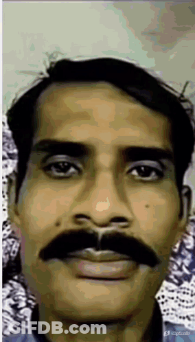 A Man With A Mustache Is Looking At The Camera GIF