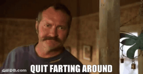 A Man With A Mustache Is Looking At The Camera With The Words Quit Farting Around Below Him GIF
