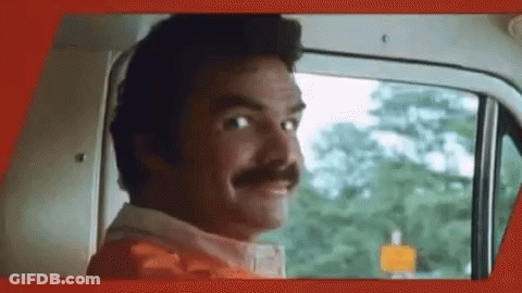 A Man With A Mustache Is Looking Out The Window Of A Car . GIF