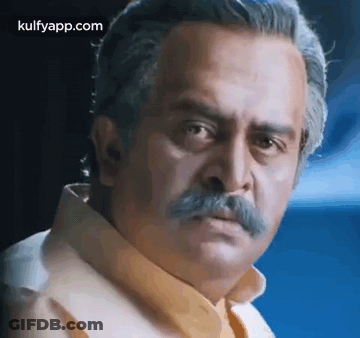 A Man With A Mustache Is Making A Funny Face And Looking At The Camera . GIF