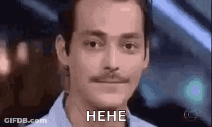 A Man With A Mustache Is Making A Funny Face And Saying , `` Heh '' . GIF