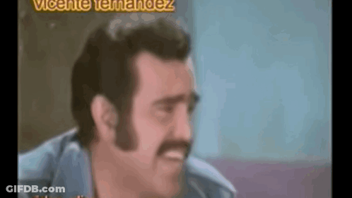A Man With A Mustache Is Making A Funny Face In A Video . GIF