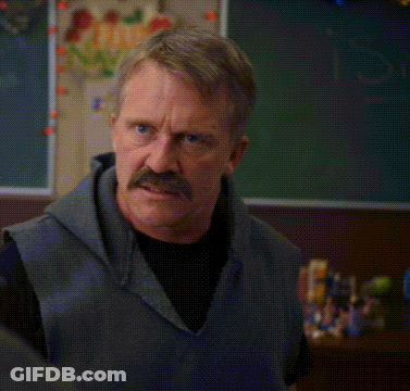 A Man With A Mustache Is Making A Funny Face In Front Of A Sign That Says I Don 'T Get It GIF