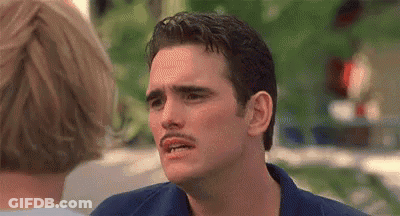 A Man With A Mustache Is Making A Funny Face In Front Of A Woman . GIF