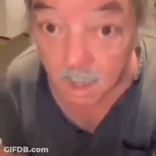 A Man With A Mustache Is Making A Funny Face While Looking At The Camera . GIF