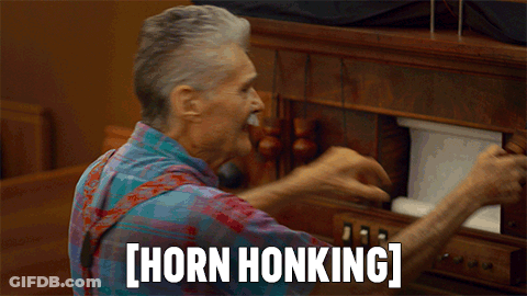 A Man With A Mustache Is Playing A Horn Honking Toy GIF