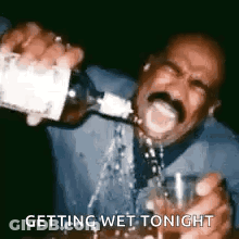 A Man With A Mustache Is Pouring A Drink Into A Glass . GIF