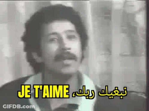 A Man With A Mustache Is Singing A Song In A Black And White Video . GIF