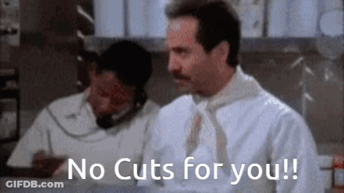 A Man With A Mustache Is Sitting At A Counter Talking On A Phone And Says `` No Cuts For You ! '' GIF